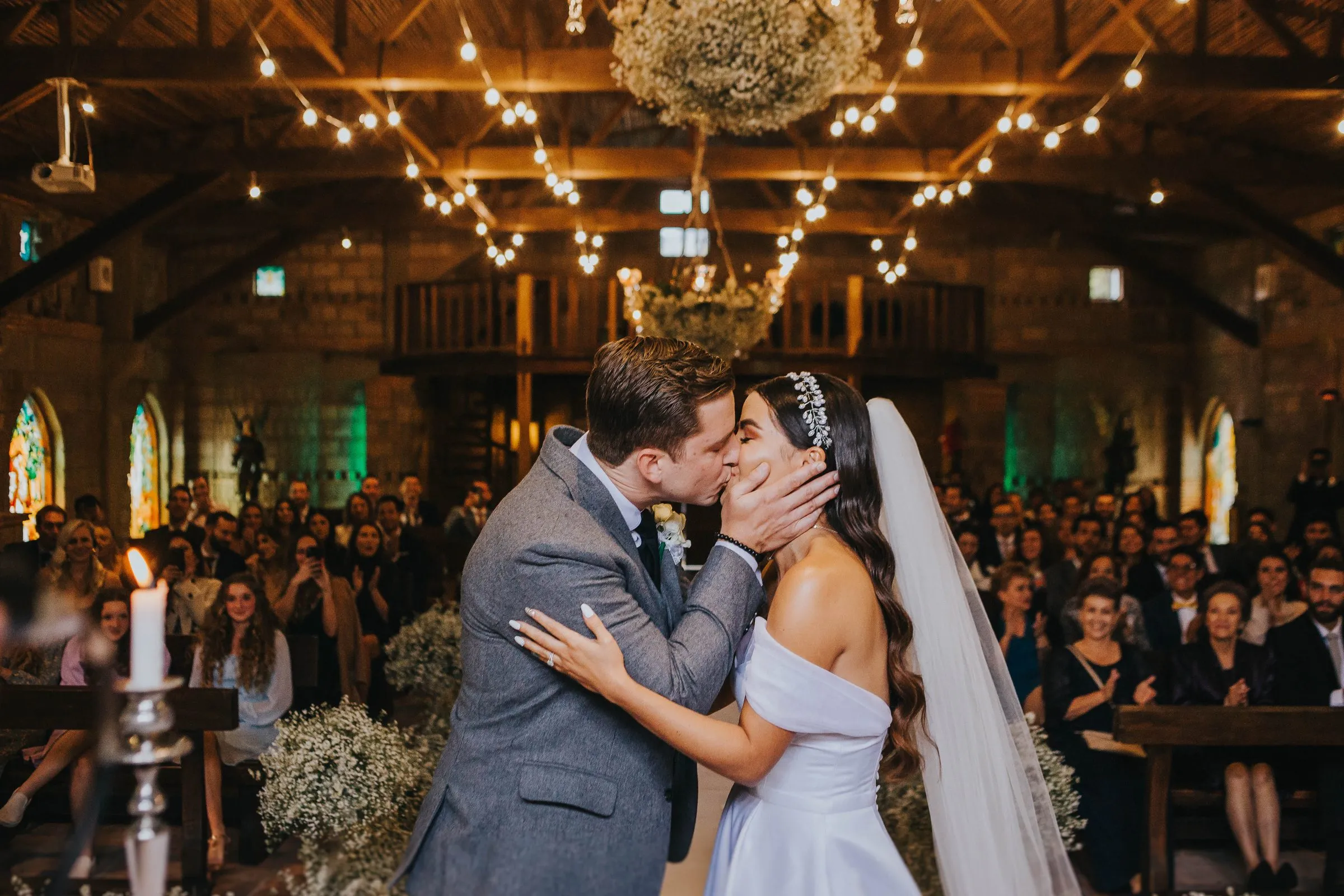 Novios besándose durante su boda, entre luces cálidas